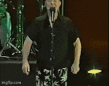 a man is playing drums in front of a microphone in a recording studio .