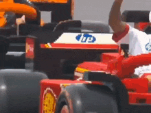 a man is taking a picture of a race car with a phone .