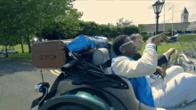 a man in a blue and white varsity jacket is pointing at something
