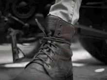 a close up of a person 's leg wearing a pair of brown boots that say ' harley davidson ' on them