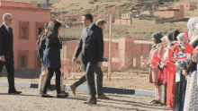 a group of people holding british flags are walking down a dirt road