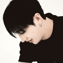 a close up of a person 's ear with a black shirt on