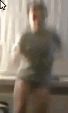 a blurry picture of a person standing in front of a window with a mouse pointer .