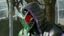 a green and purple superhero with a hood