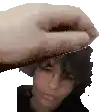 a hand is holding a person 's head in front of a white background
