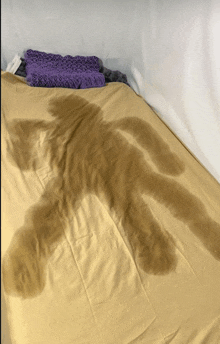 a bed with a yellow blanket and a purple blanket