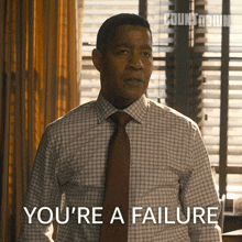a man in a checkered shirt and tie says you 're a failure