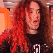 a man with long red hair is wearing a black t-shirt with the number 51 on it