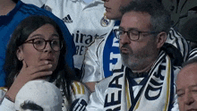 a man wearing glasses and a scarf with the word real on it