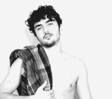 a shirtless man wearing a plaid scarf around his shoulder