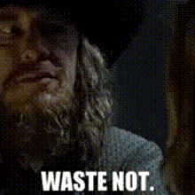 a man with a beard and a hat says " waste not "