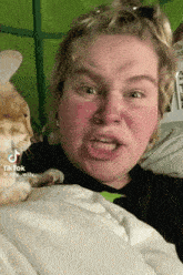 a woman making a funny face next to a cat with a tiktok watermark