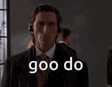 a man in a suit and tie is wearing headphones and the word goo do is on the screen