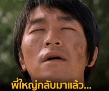 a close up of a man 's face with his eyes closed and a foreign language written below him