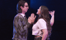 a man and a woman are standing next to each other and the woman is wearing a crop top