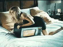 a woman laying on a bed with a microwave