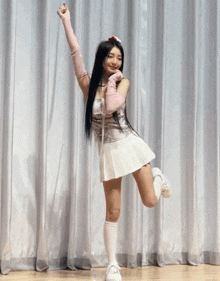 a woman in a white skirt and pink gloves is dancing