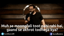 a man stands in front of a microphone with a quote from kunalkamra