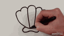 a person is drawing a seashell with a black marker and the words made in animotica are below it