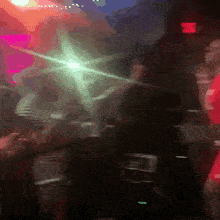 a blurry picture of people dancing in a club with a red exit sign in the background