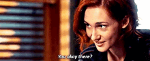 a woman with red hair is smiling and asking if she is okay .