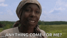 a woman wearing a head scarf is smiling in a field and asking anything come for me .