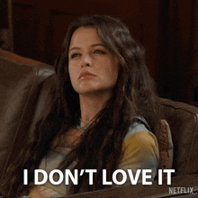 a woman sitting on a couch with the words i don 't love it on her face