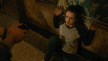 a young girl is sitting on the floor with her hands on the wall