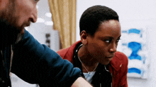 a man and a woman are looking at something in a room .