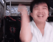 a man is making a funny face with his arms in the air .