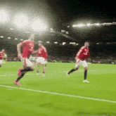 a blurred image of soccer players on a field with one wearing a jersey that says ' united '