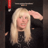 a woman with blonde hair is saluting in front of a g1 logo