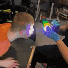 a person is holding a rainbow colored cube in front of a boy 's face .