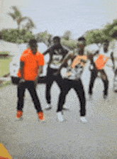 a blurry picture of a group of men dancing on a street .
