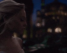 a woman in a white dress stands in the dark