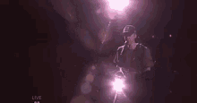 a man in a baseball cap is playing drums on a stage .
