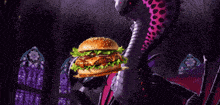 a purple dragon holding a hamburger in its mouth