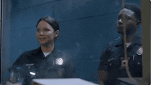two police officers are giving a thumbs up in a dark room