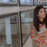 a woman is standing in front of a window in a store .