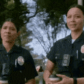 two female police officers are standing next to each other holding cups of coffee