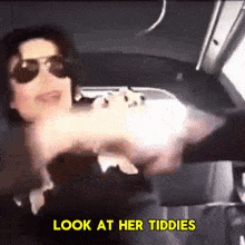 a man wearing sunglasses is holding a gun and says look at her tiddies in yellow letters