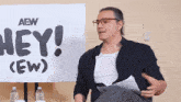a man in front of a sign that says hey