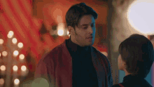 a man and a woman are standing next to each other in a room .