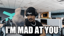 a man wearing headphones and a hat says " i 'm mad at you "