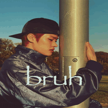 a man wearing a hat and a jacket with the word bruh on the sleeve