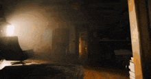 a dark room with a light shining through the door