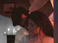 a man kissing a woman 's neck in a dark room