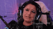 a woman wearing headphones and glasses is looking at a math problem