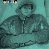 a person wearing a hooded jacket with chinese writing on it is laying down .