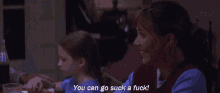 a woman sitting at a table with a child says you can go suck a fuck
